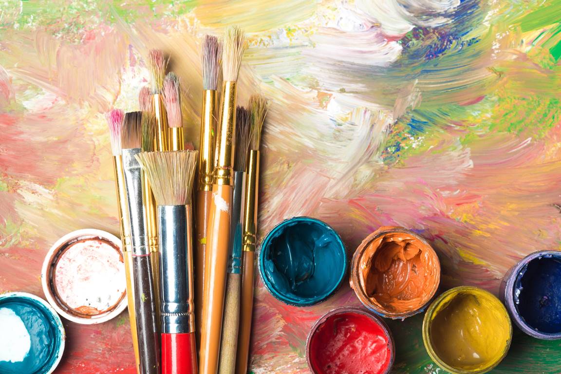 Instructor guiding a child in painting a colorful masterpiece