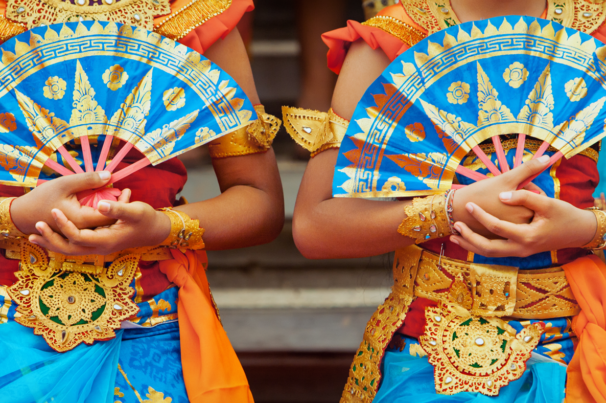 Dancers in traditional Balinese costumes holding ornate blue and gold fans – World Dance