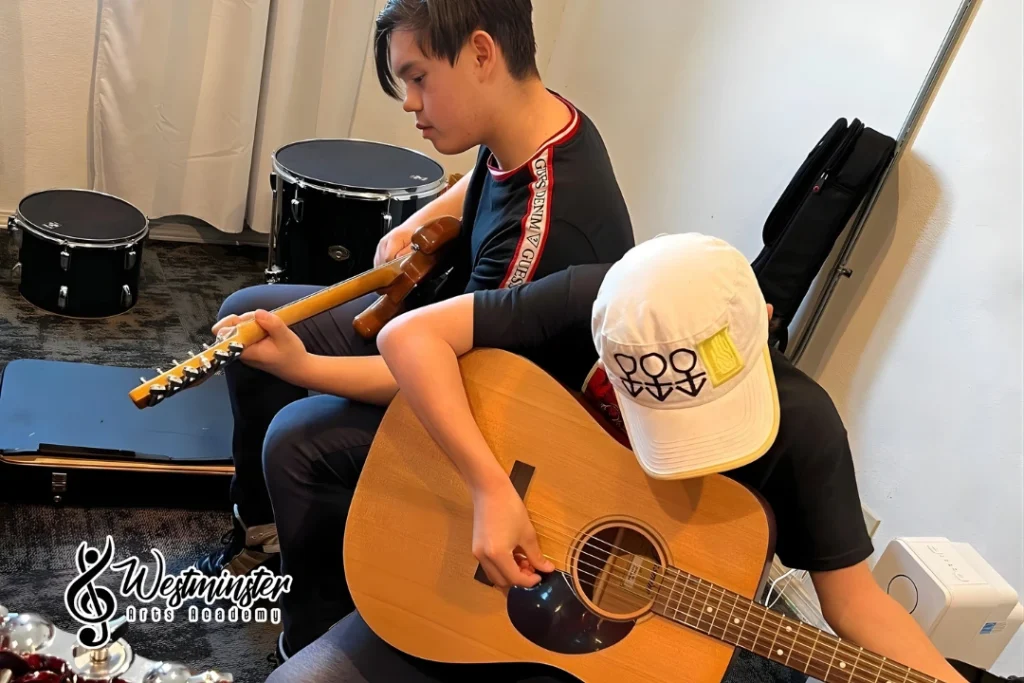 Beginner learning to play guitar in Westminster, practicing basic chords and strumming at Westminster Arts Academy.