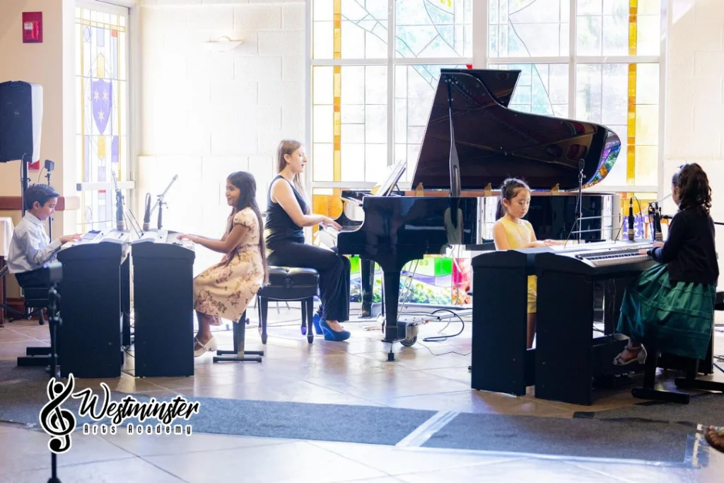 Young students learning piano with an instructor during a music class in Westminster, CA